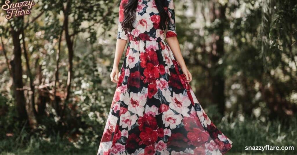 Person wearing a floral dress with red and white flowers, standing outdoors. snazzyflare