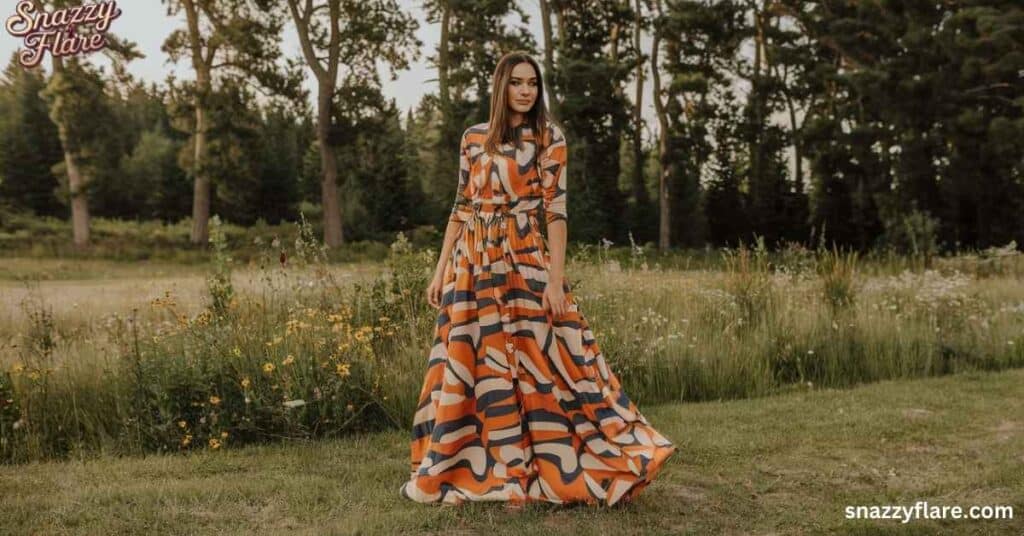 Woman in a long, colorful dress stands in a field of wildflowers, promoting Snazzyflare.