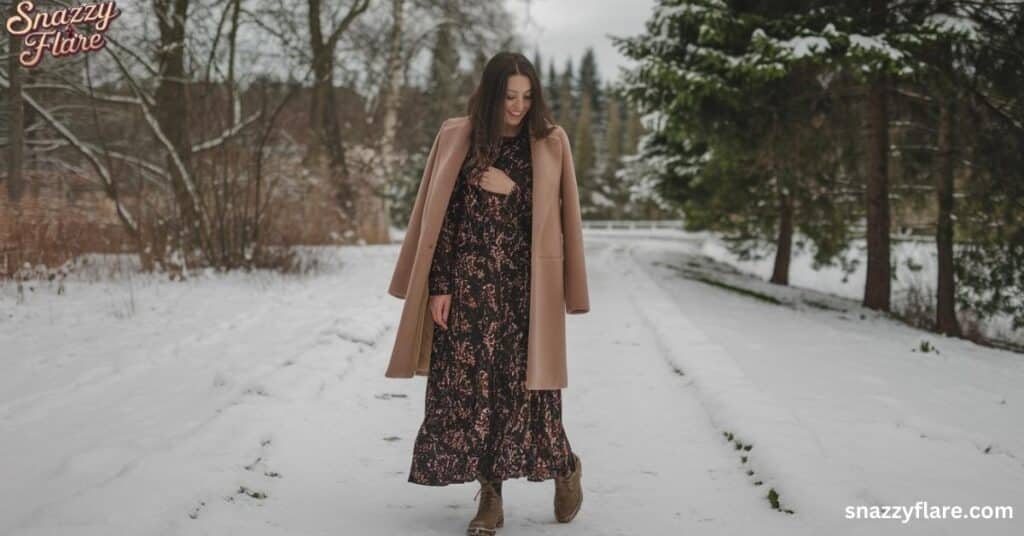 Model in a floral Maxi dress and beige coat on a snowy path, snazzyflare.